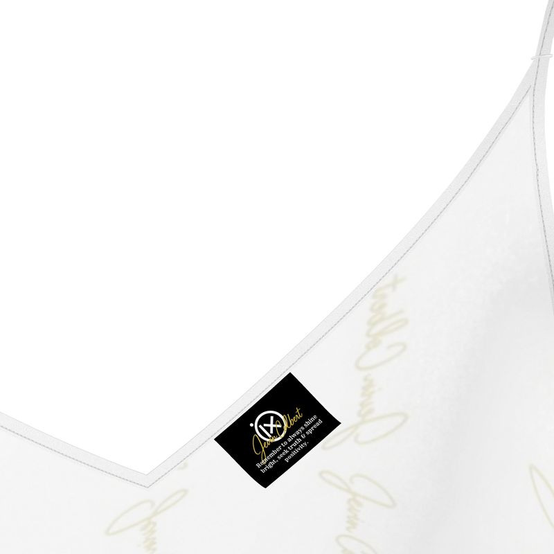 White satin slip dress neckline close-up with brand tag and gold embroidery