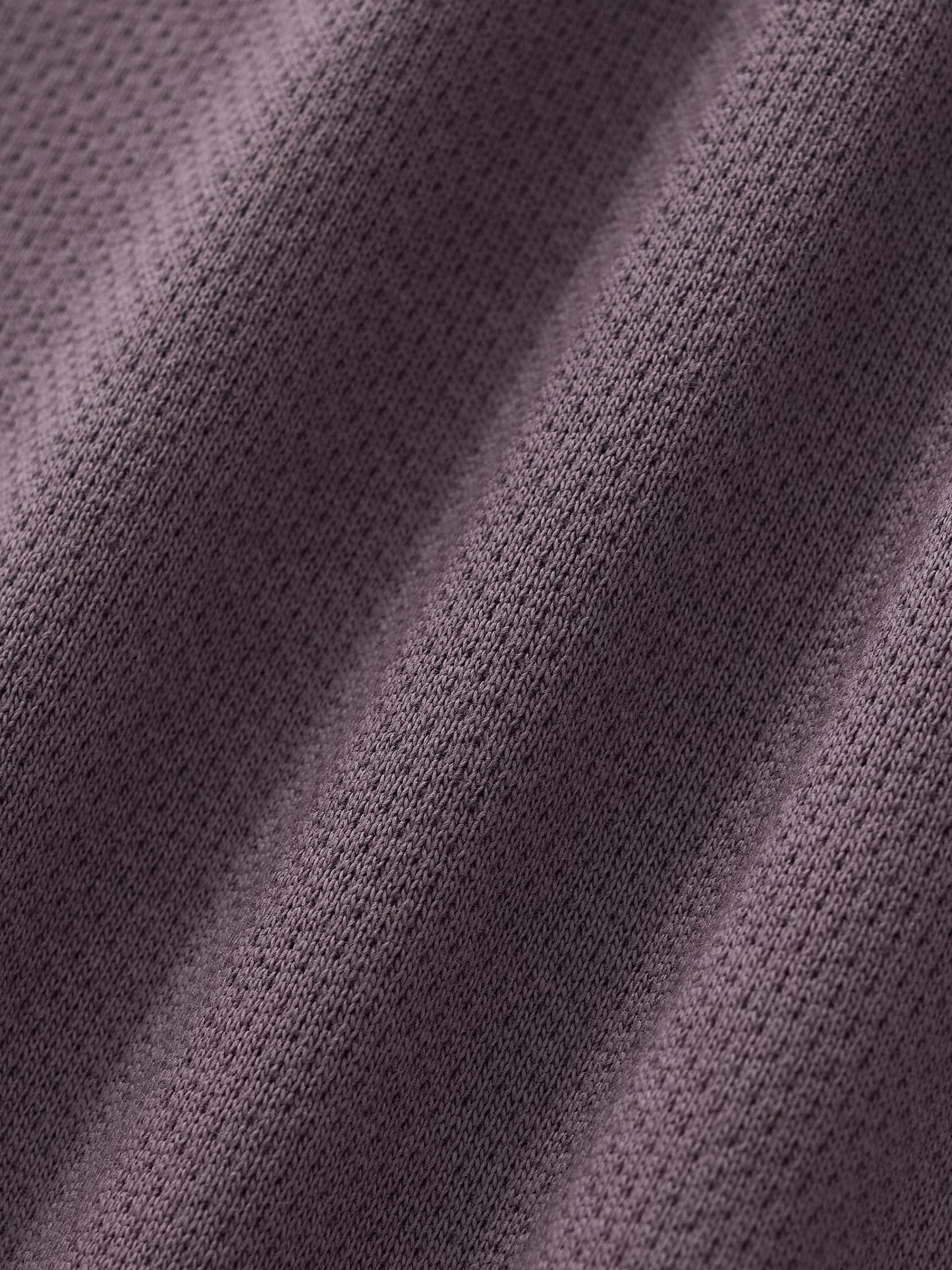 Cropped track jacket fabric close-up with knit texture and seam detail