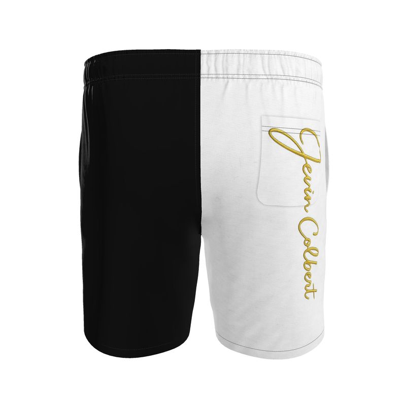 Two-tone men's swim shorts with black left, white right, gold script, zip pocket