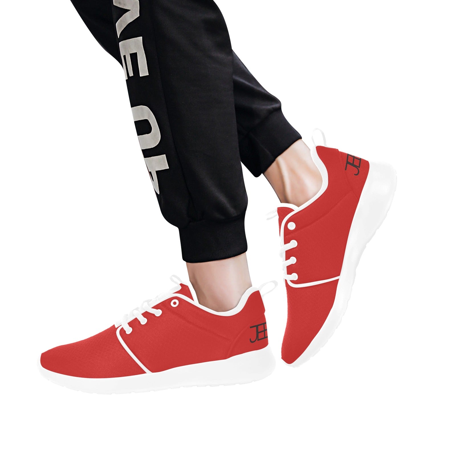 Red mens runner sneakers with white trim, worn with black pants