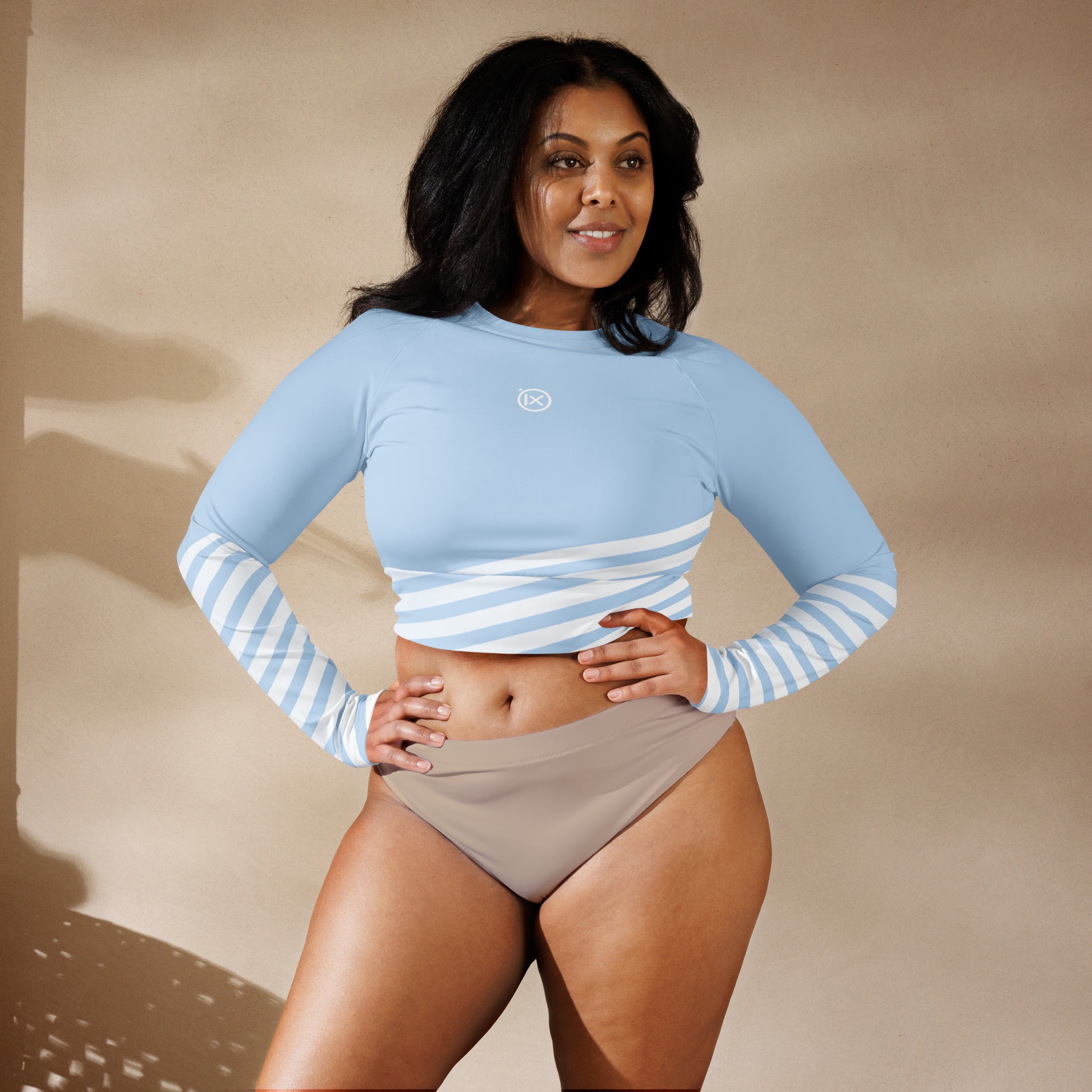 Light blue long-sleeve crop top with striped band on back and white logo mark