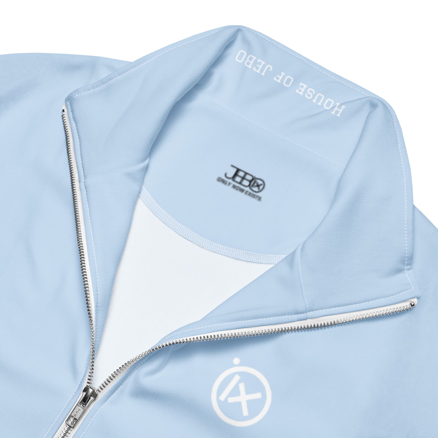 Light blue track jacket interior close-up with branded label and zipper edge