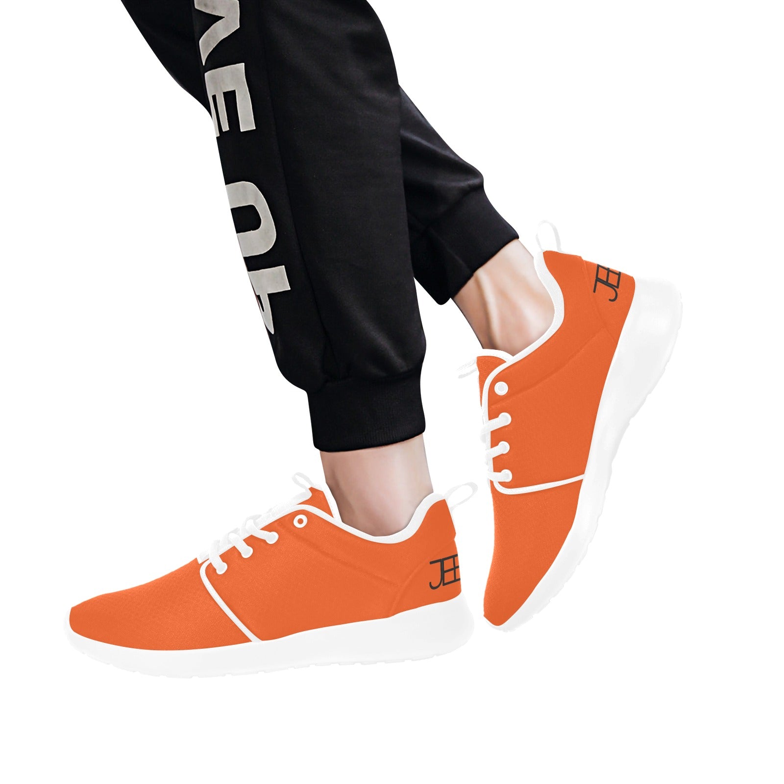 Men's running shoes, orange uppers with white laces and thick white soles on feet