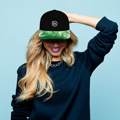 Baseball cap worn by person: black crown, green camo brim, Ix logo