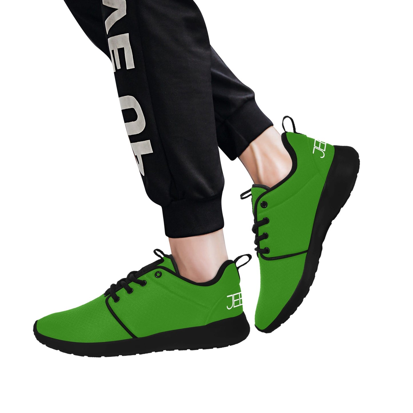 Mens performance running shoes worn with black pants, green lace-up style