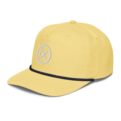 Yellow snapback cap with navy edge, curved brim, and white circular X logo.