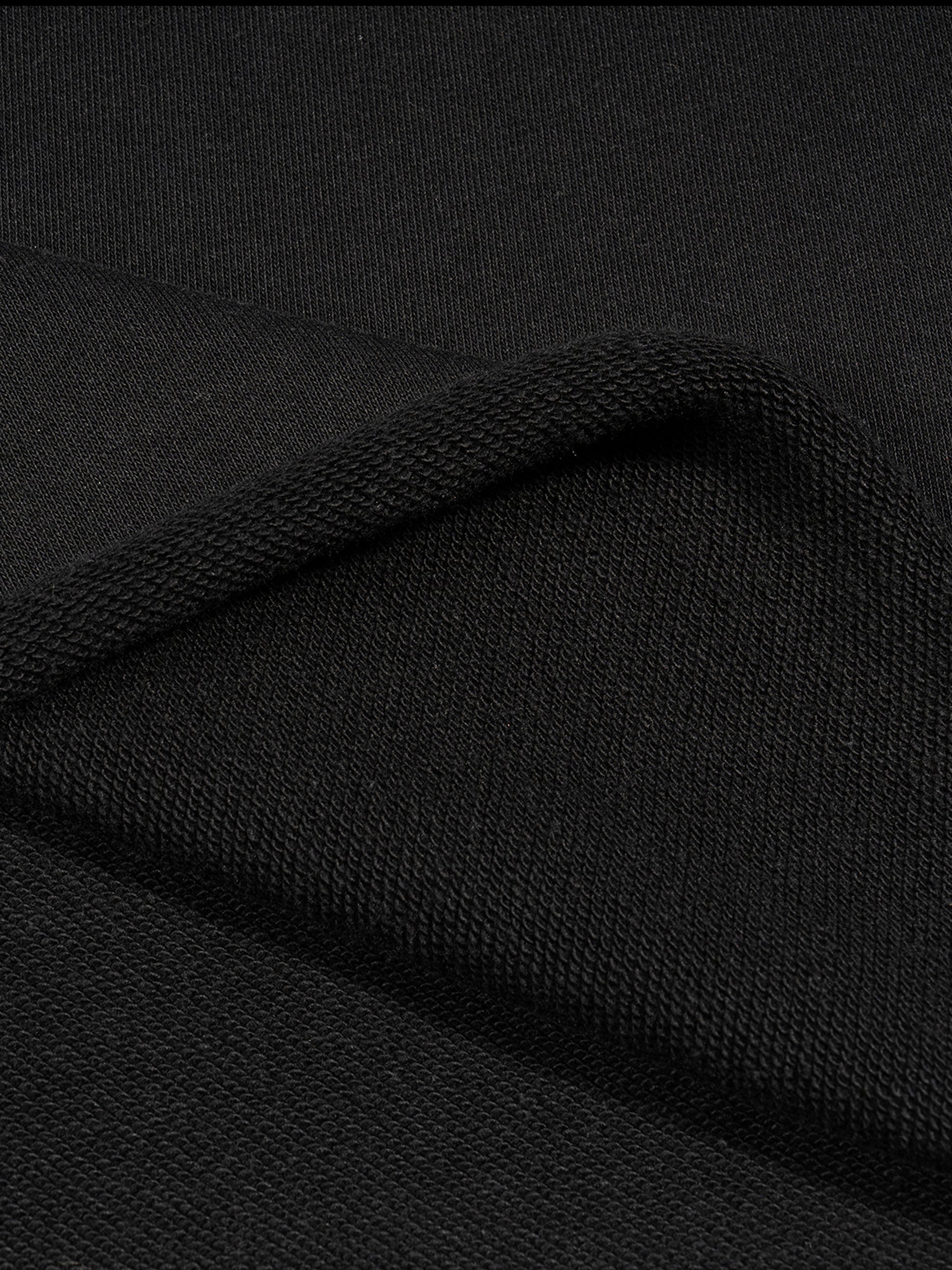 Black French terry fabric texture close-up with stitched fold