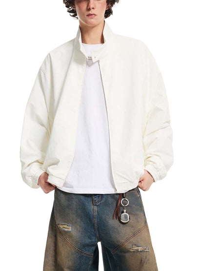 White stand-collar bomber jacket with front zipper and ribbed cuffs on a model.