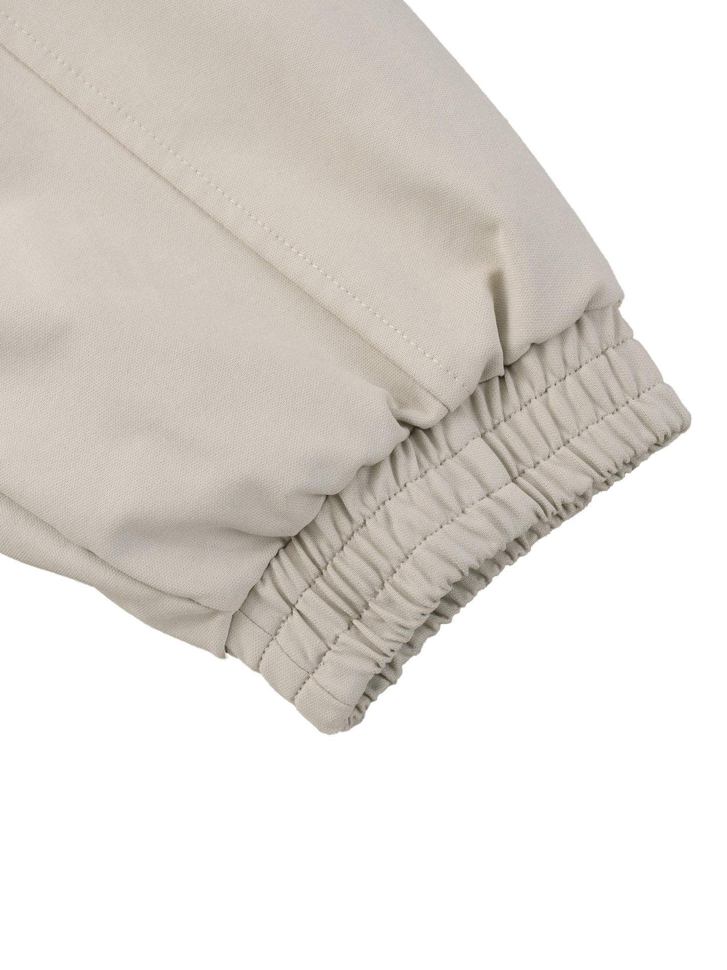 Beige bomber jacket sleeve cuff with elastic gathering and stitched seam