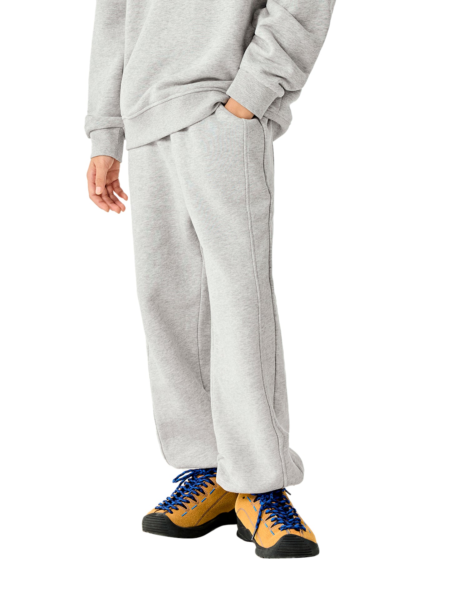 Kids fleece jogger in light gray worn with sneakers, elastic waistband and cuffed legs
