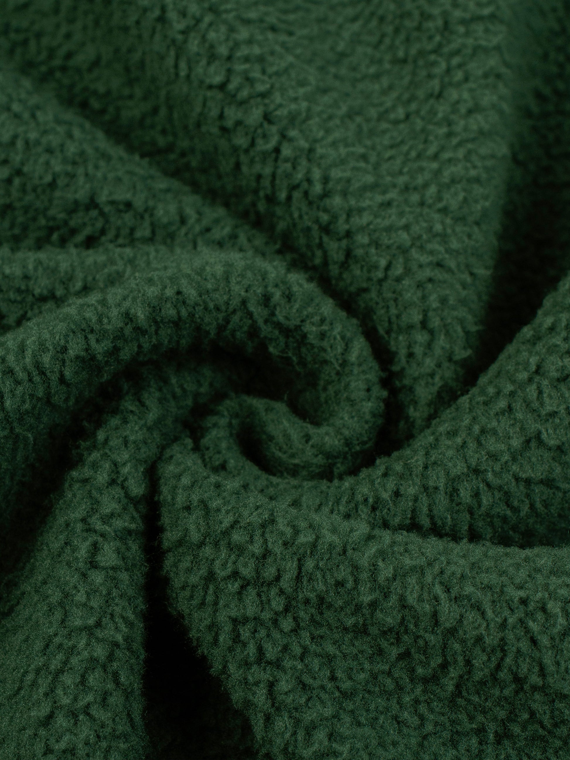 Green fleece fabric texture close-up with soft brushed pile