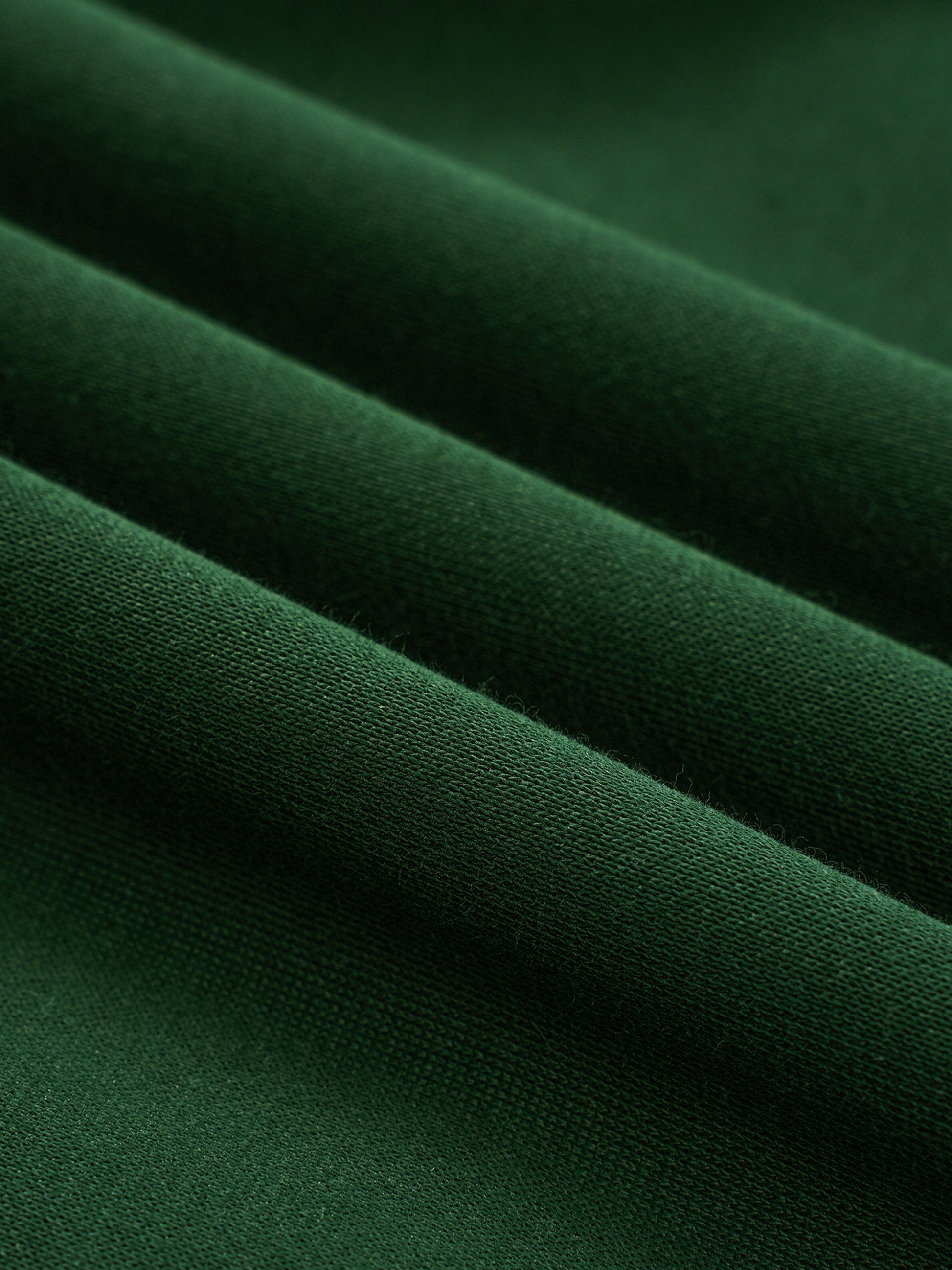 Green fleece fabric close-up with smooth knit surface