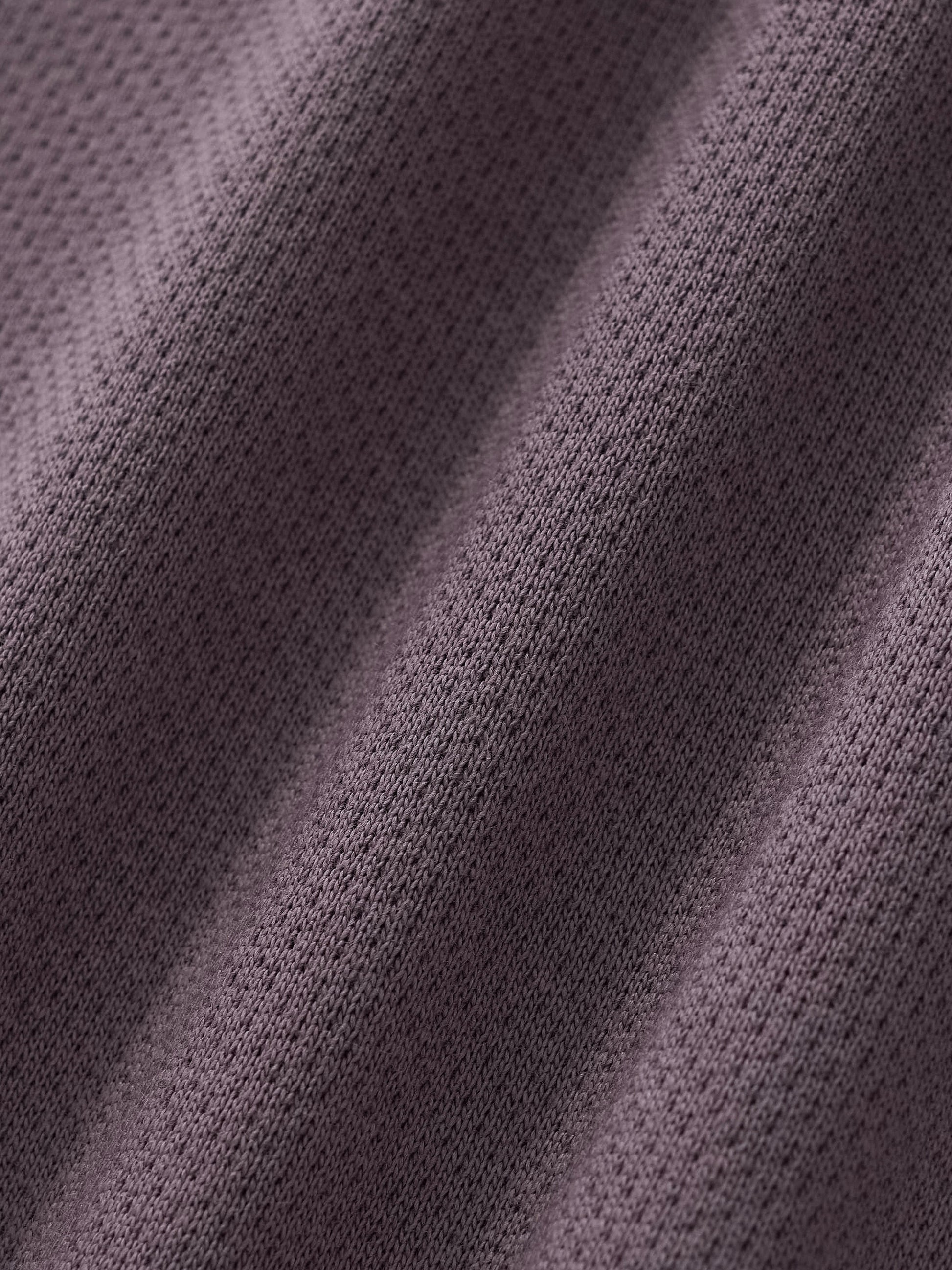 Cropped track jacket fabric close-up with knit texture and seam detail