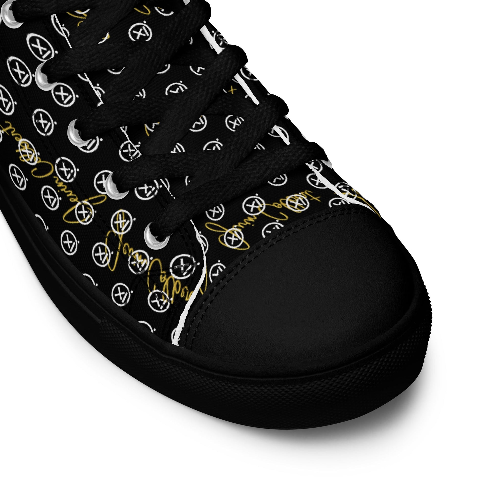 Black high-top sneaker close-up with monogram canvas upper and black rubber toe cap.