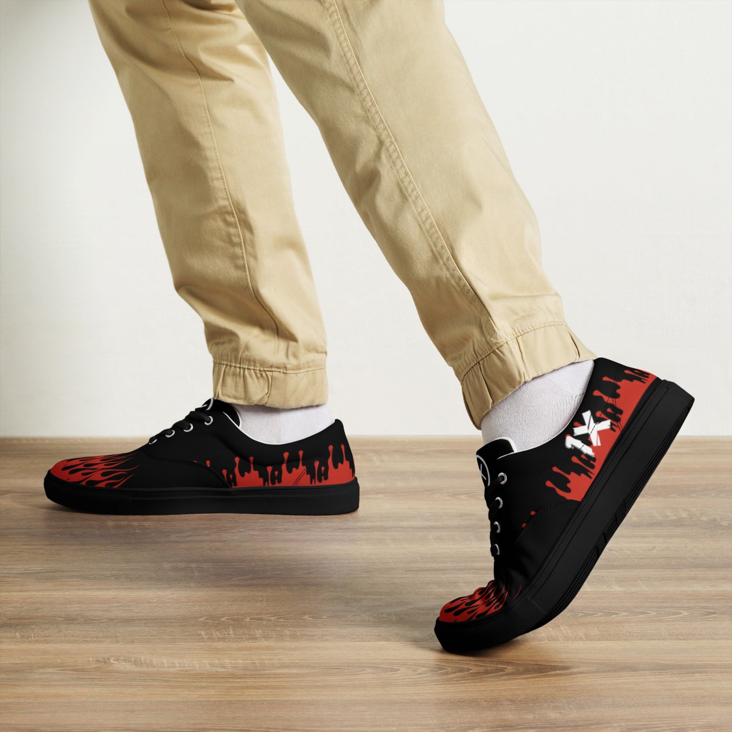 Black canvas sneakers with red flame print, white laces, side angle view.