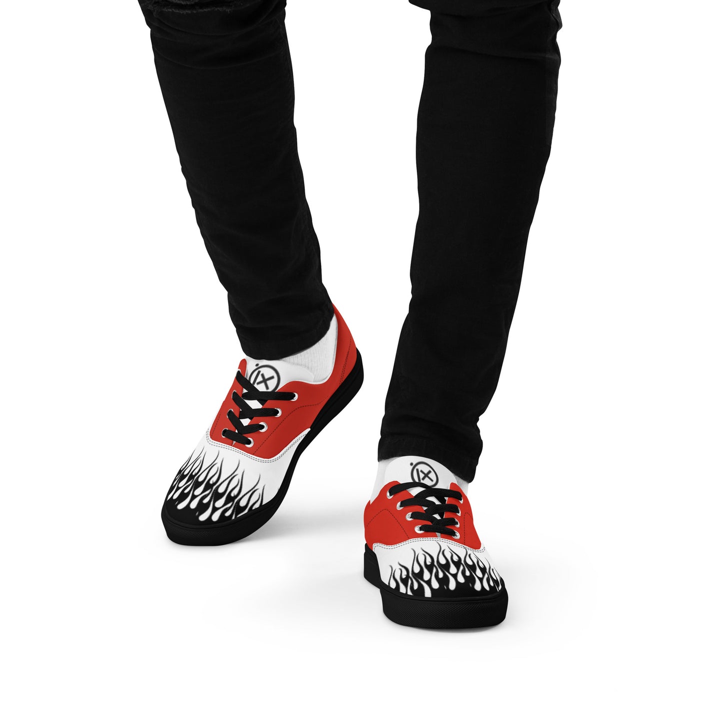 Flame-print red and white sneakers on feet with black pants