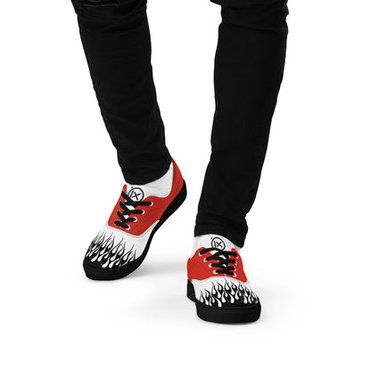 Flame-print red and white sneakers on feet with black pants