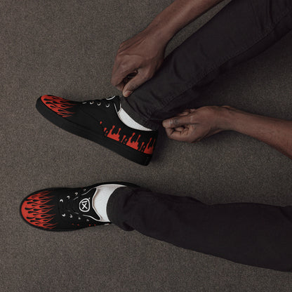 Black canvas sneakers with red flame graphic, worn with dark pants, sitting side view.