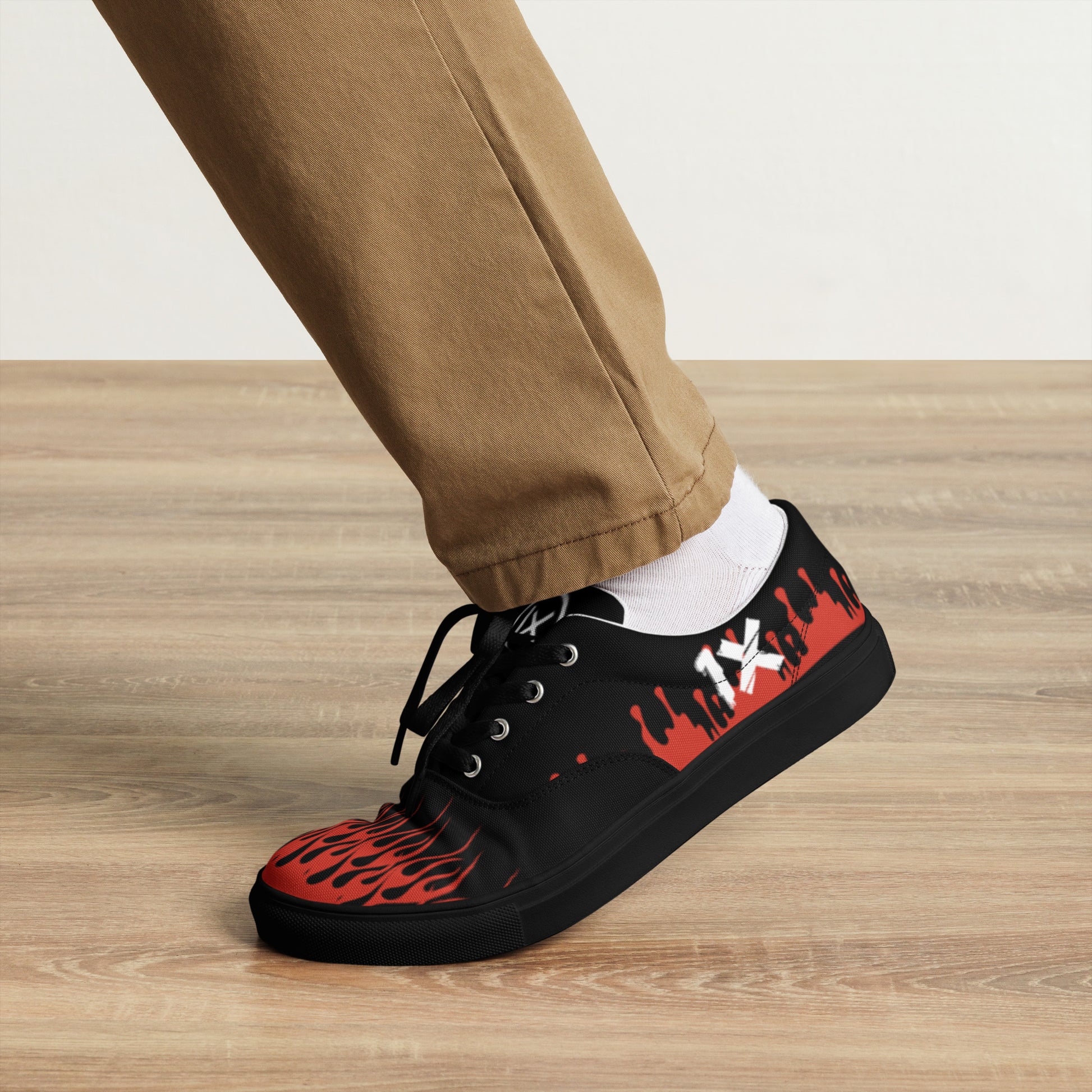 Black canvas sneaker with red flame side pattern and black outsole, lace-up style.