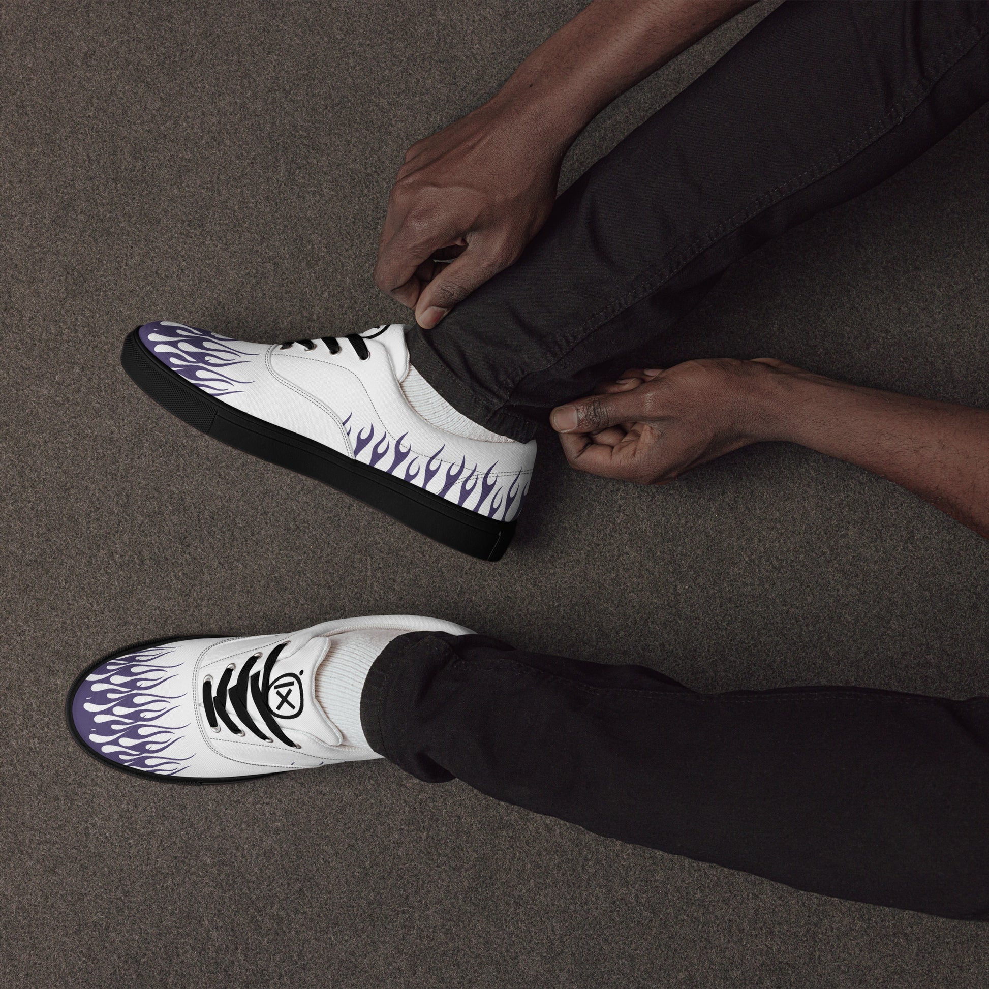 White canvas sneaker with violet flames on side and toe; black laces and sole