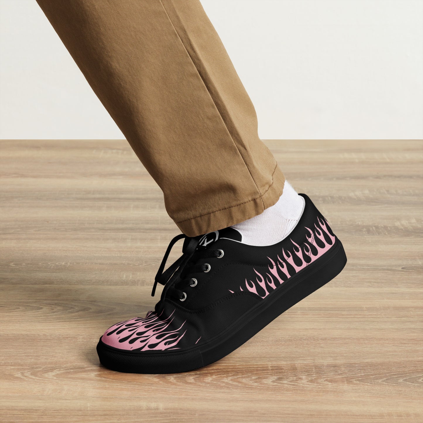Black low-top sneakers with pink flame side print and lace closure; white sock cuff