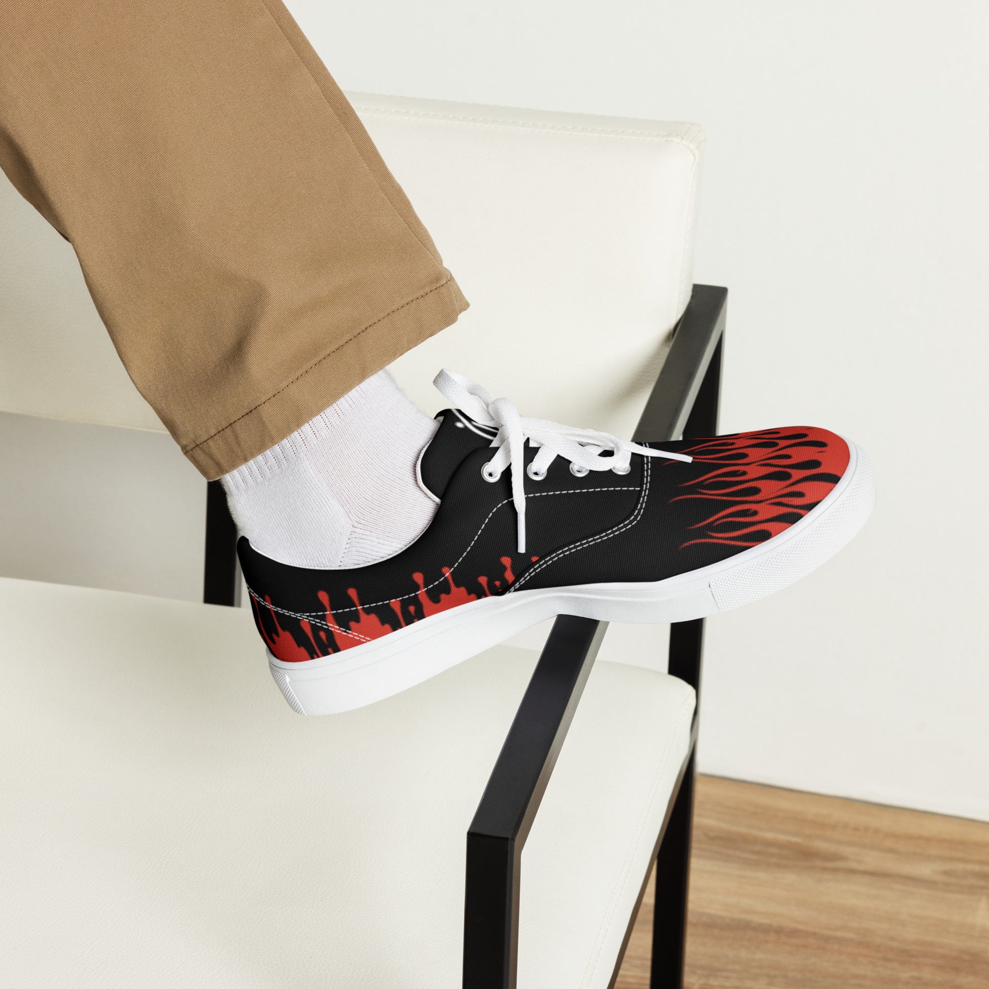 Black canvas sneaker with red flame side print, white laces, low-profile sole.
