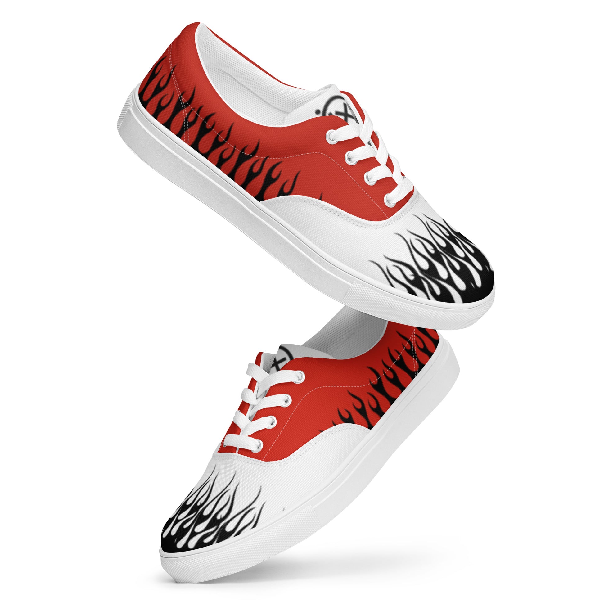 Diagonal view of red canvas low-top sneakers with white laces and black flame graphics