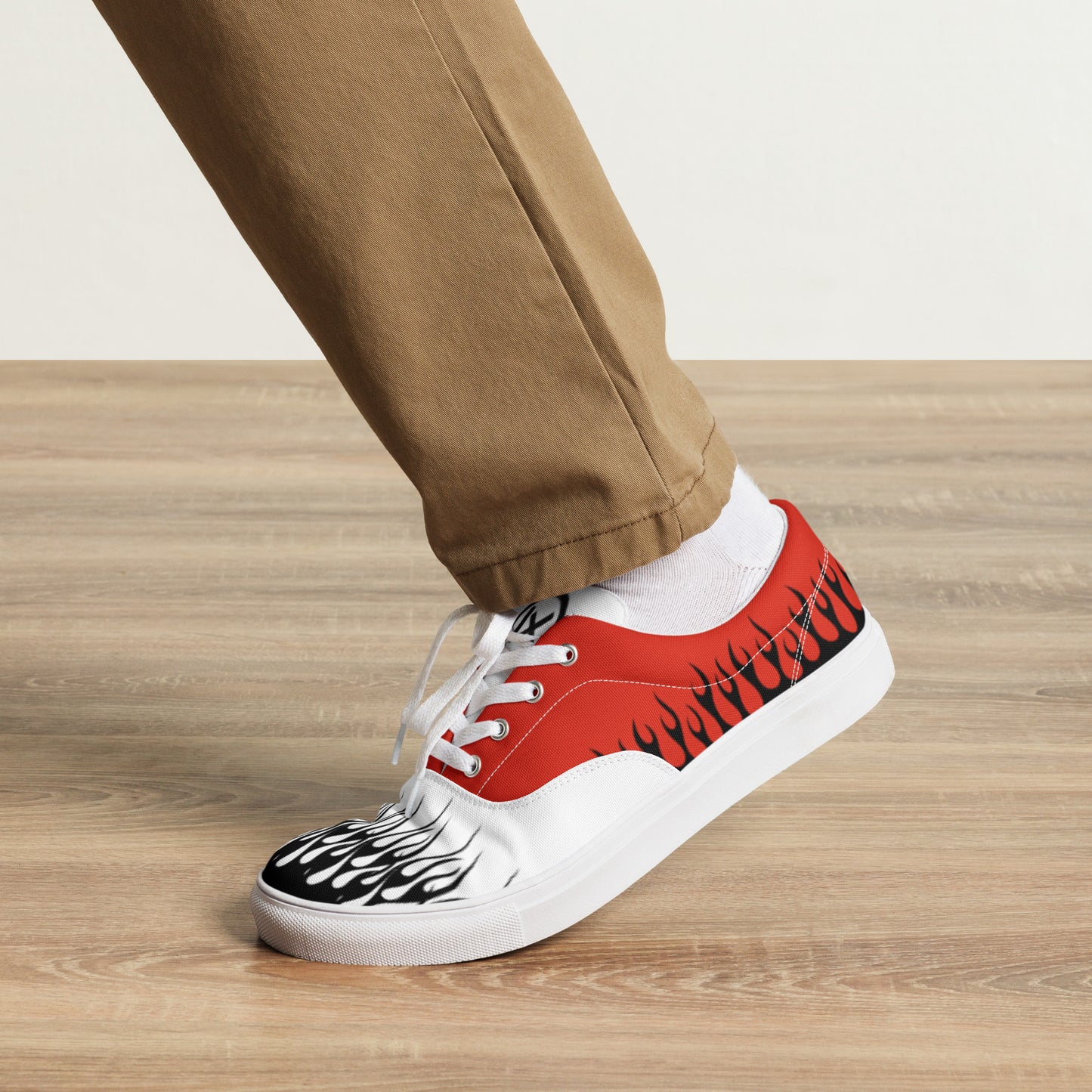 Canvas sneaker with red upper and white laces, flame artwork on toe and side