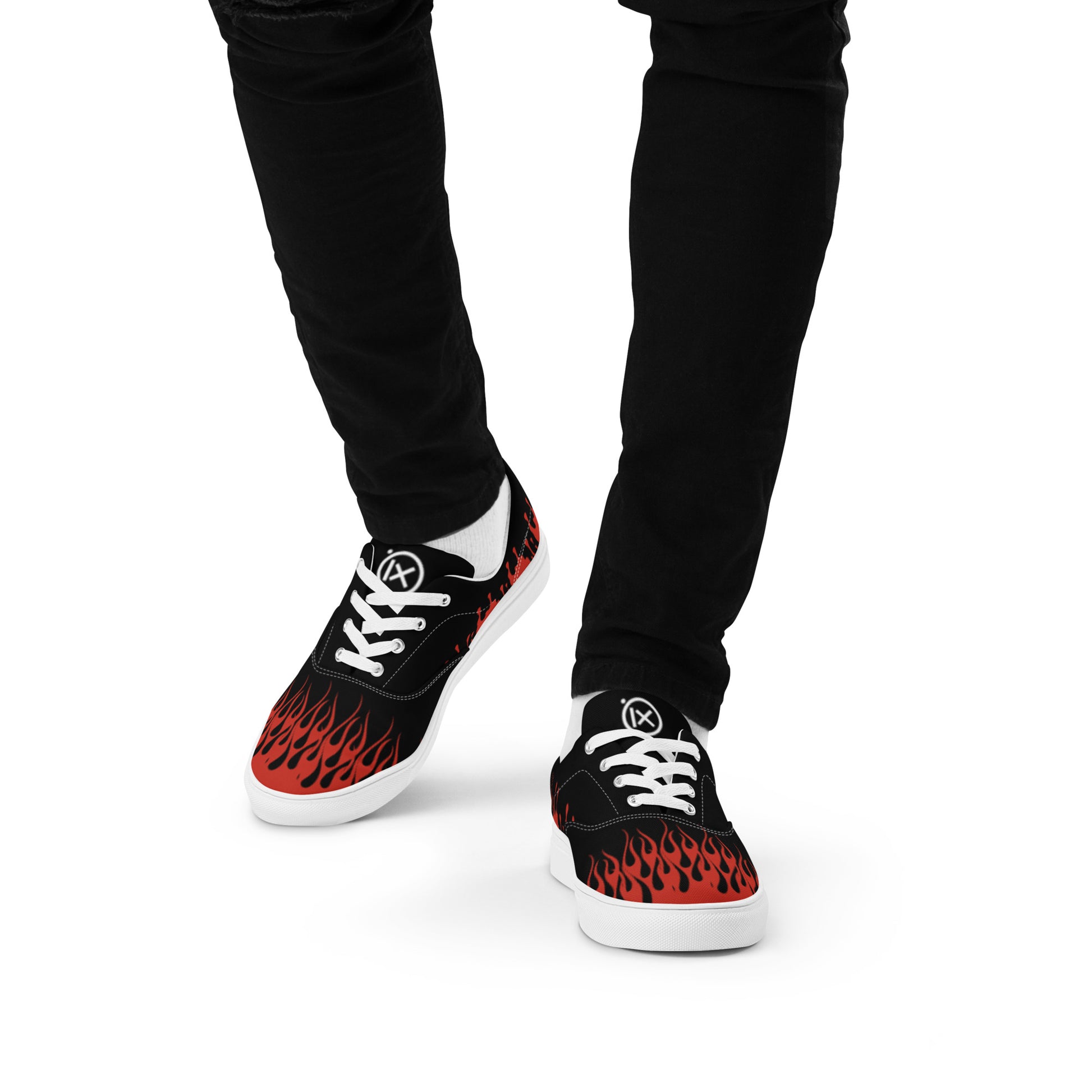 Black canvas sneakers with red flame graphic, worn with black pants, lace-up.