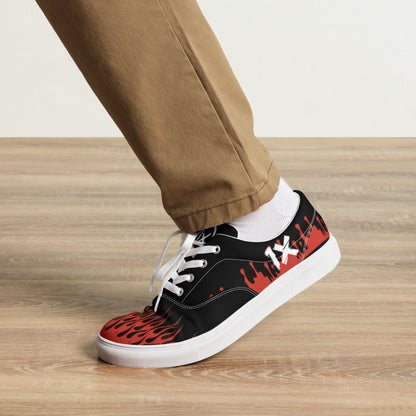 Black canvas sneaker with red flame toe and side graphic, white laces, low sole.