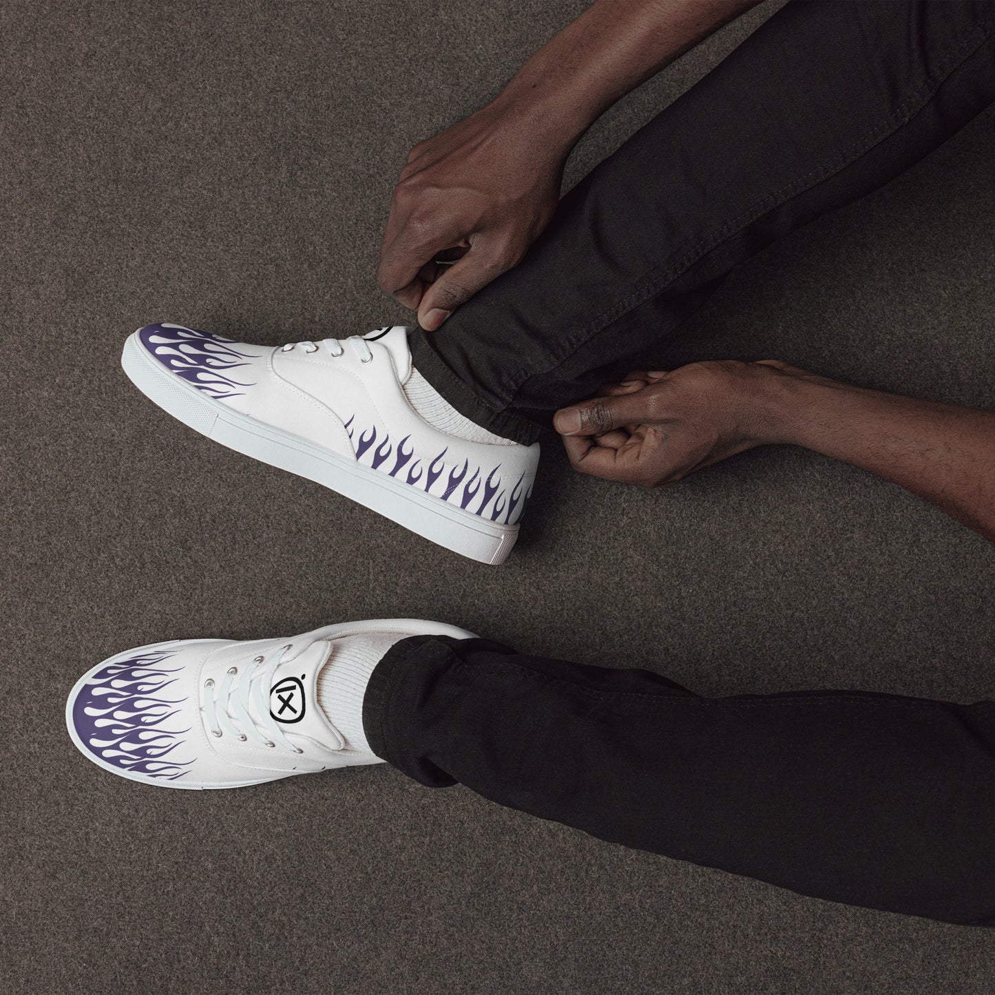 White canvas low-top sneakers with violet flame side print, black rubber sole, lace-up.