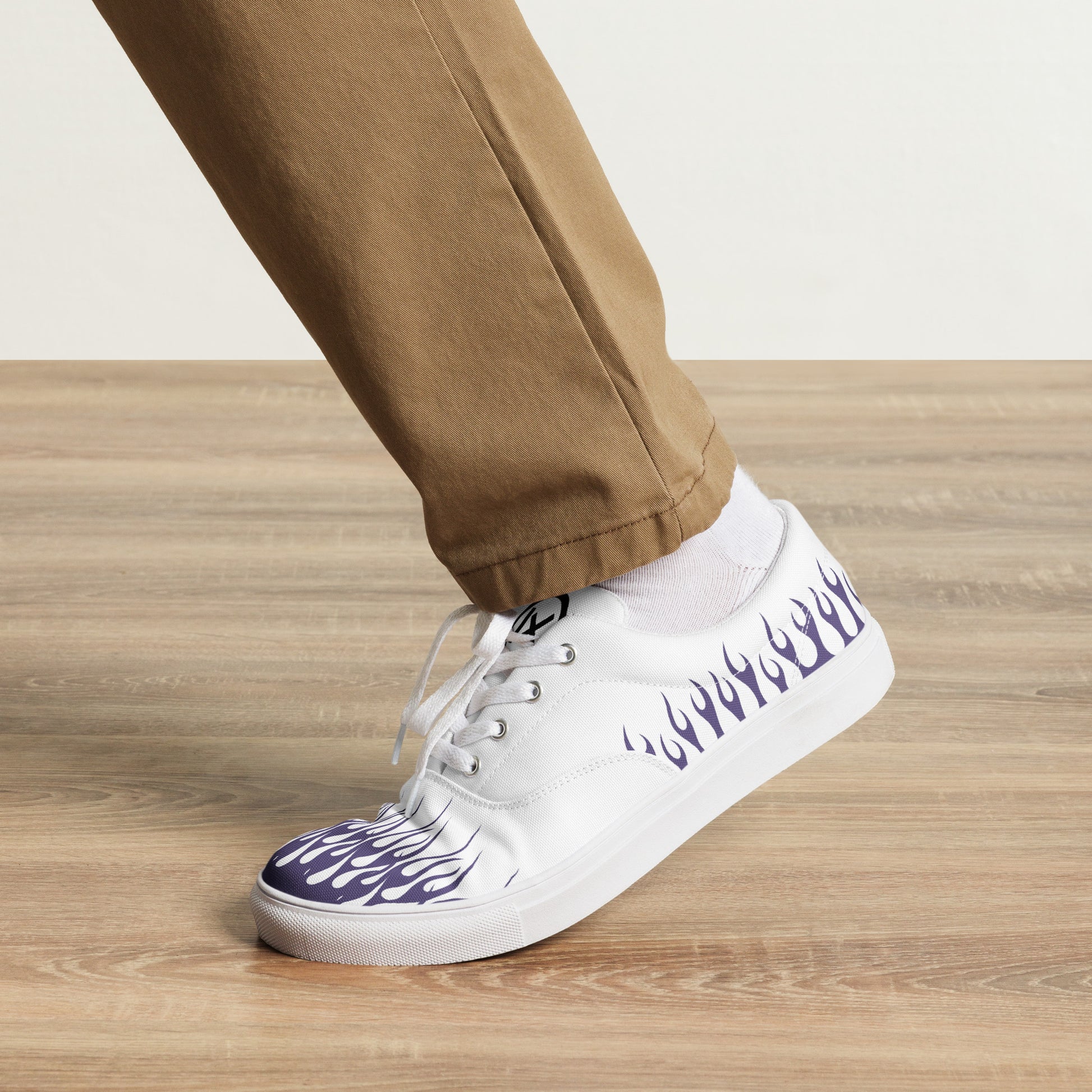 White canvas low-top sneakers with violet flame side print, white laces, black outsole.