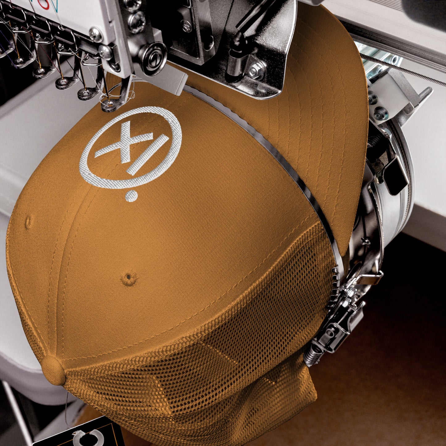 Tan trucker snapback hat with white logo patch and perforated mesh back