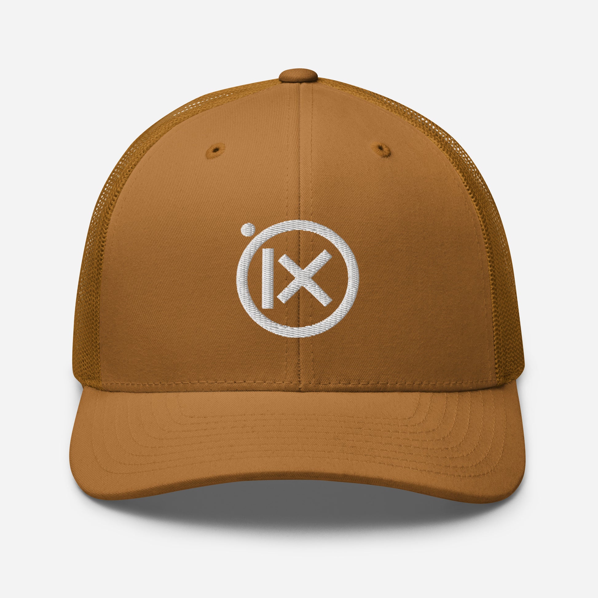 Tan trucker snapback cap with circular X logo patch and tan mesh side panels.