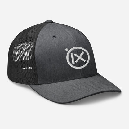 Trucker snapback cap front view, dark crown, black mesh side panels, white logo