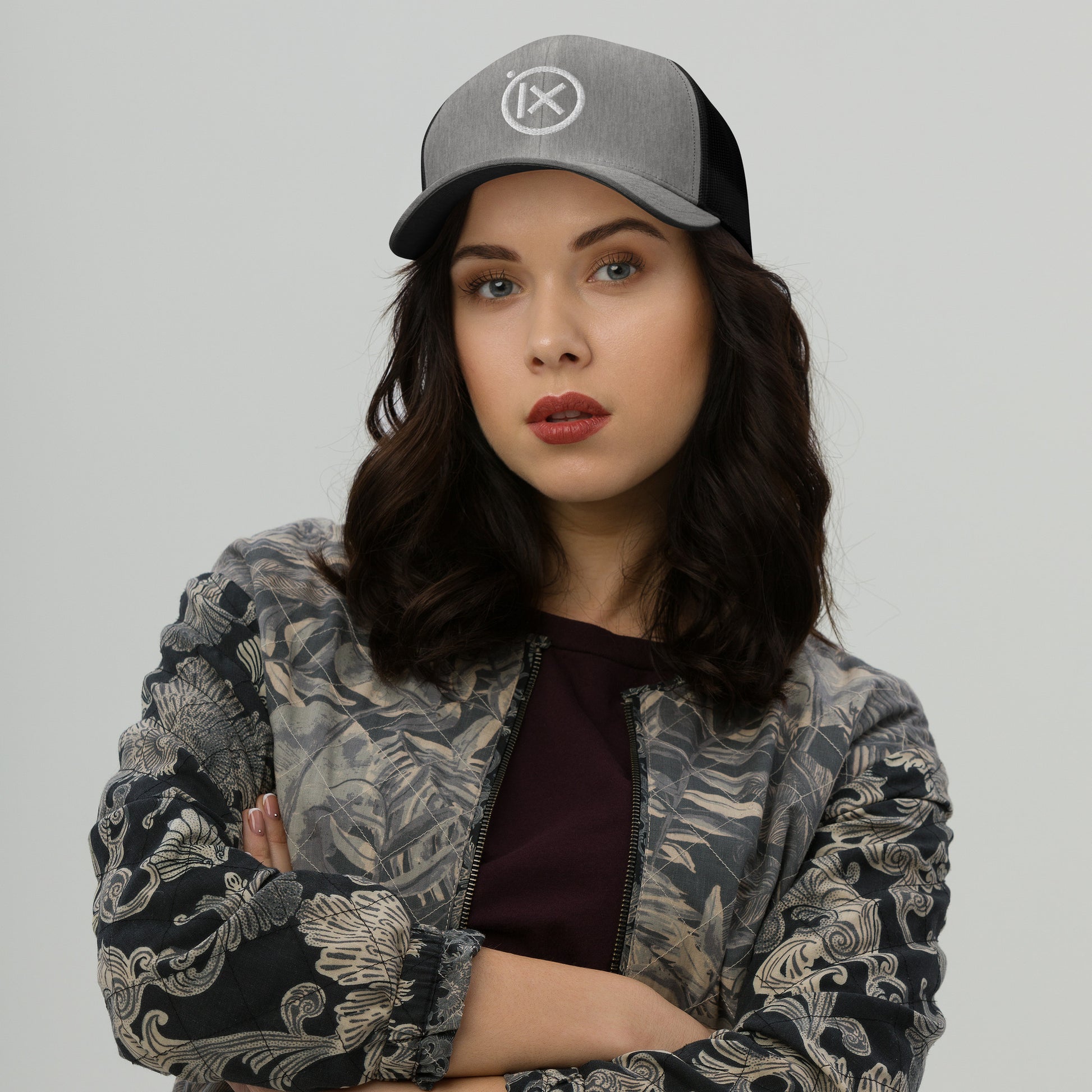 Heather gray trucker snapback hat with white logo patch and black mesh back