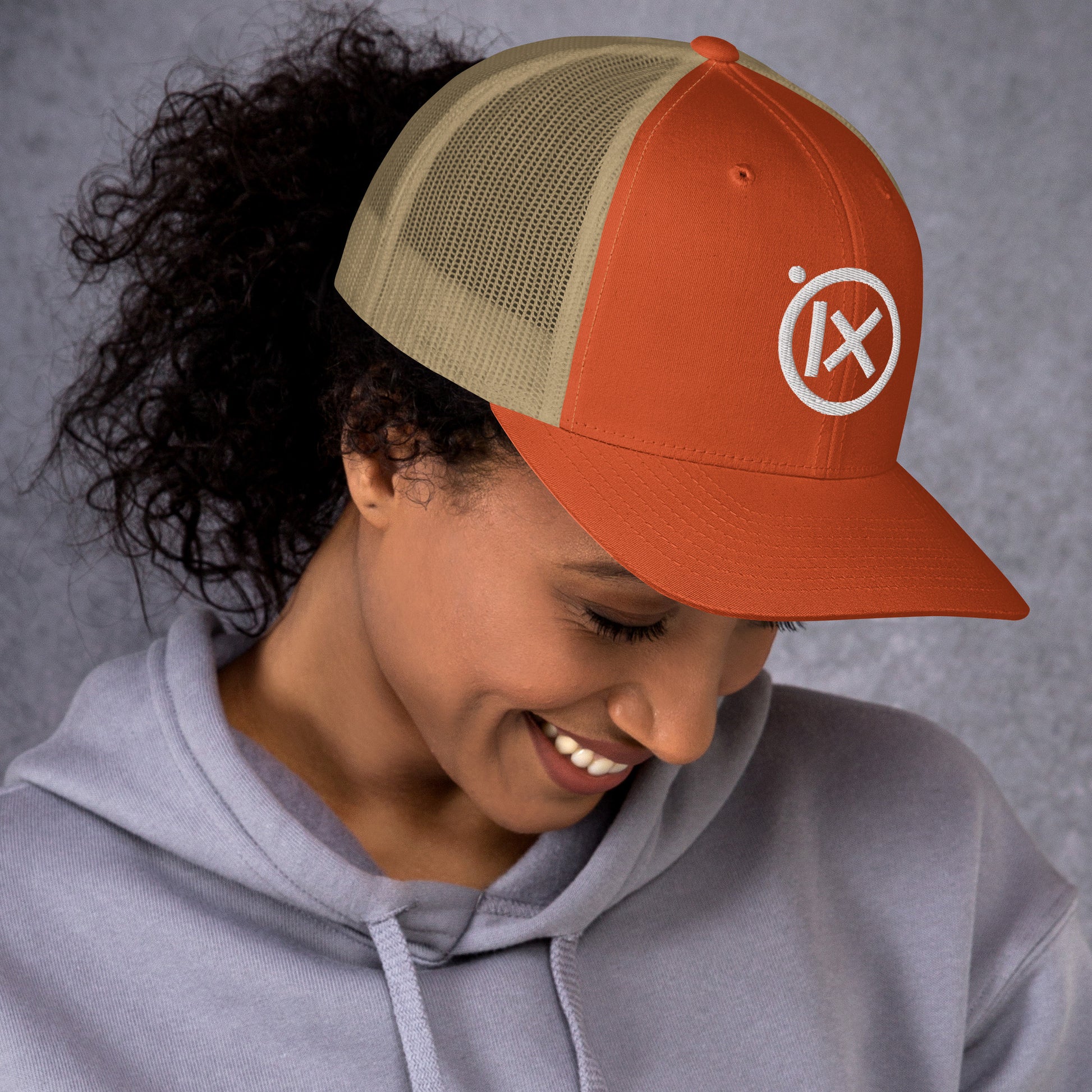 Retro trucker snapback cap in orange with tan mesh panels and circular logo patch