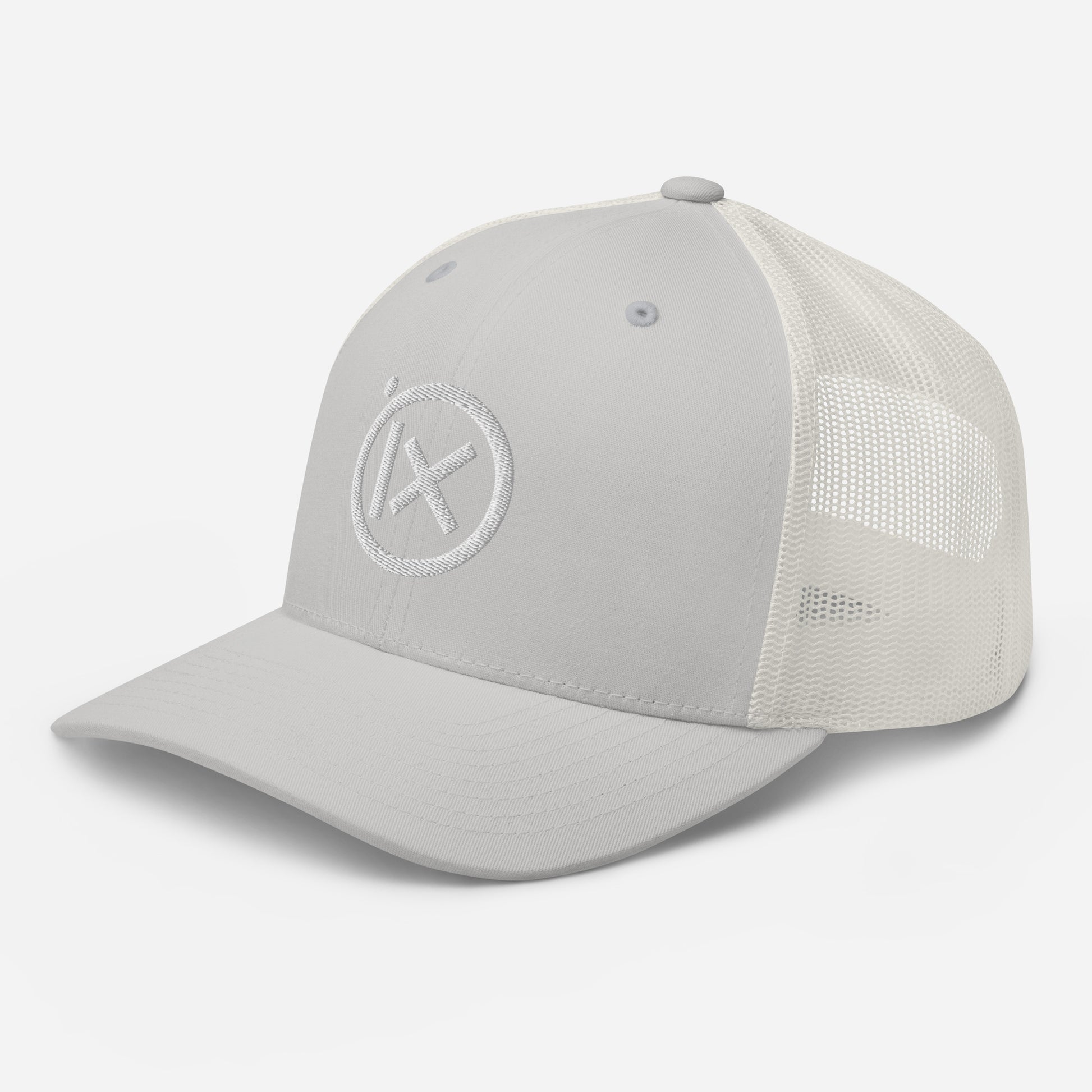 White trucker snapback cap with circular X logo patch and white mesh side panels.