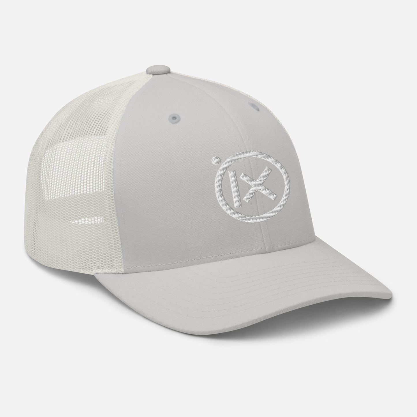 White trucker snapback cap with circular X logo patch on front panel and white mesh back.