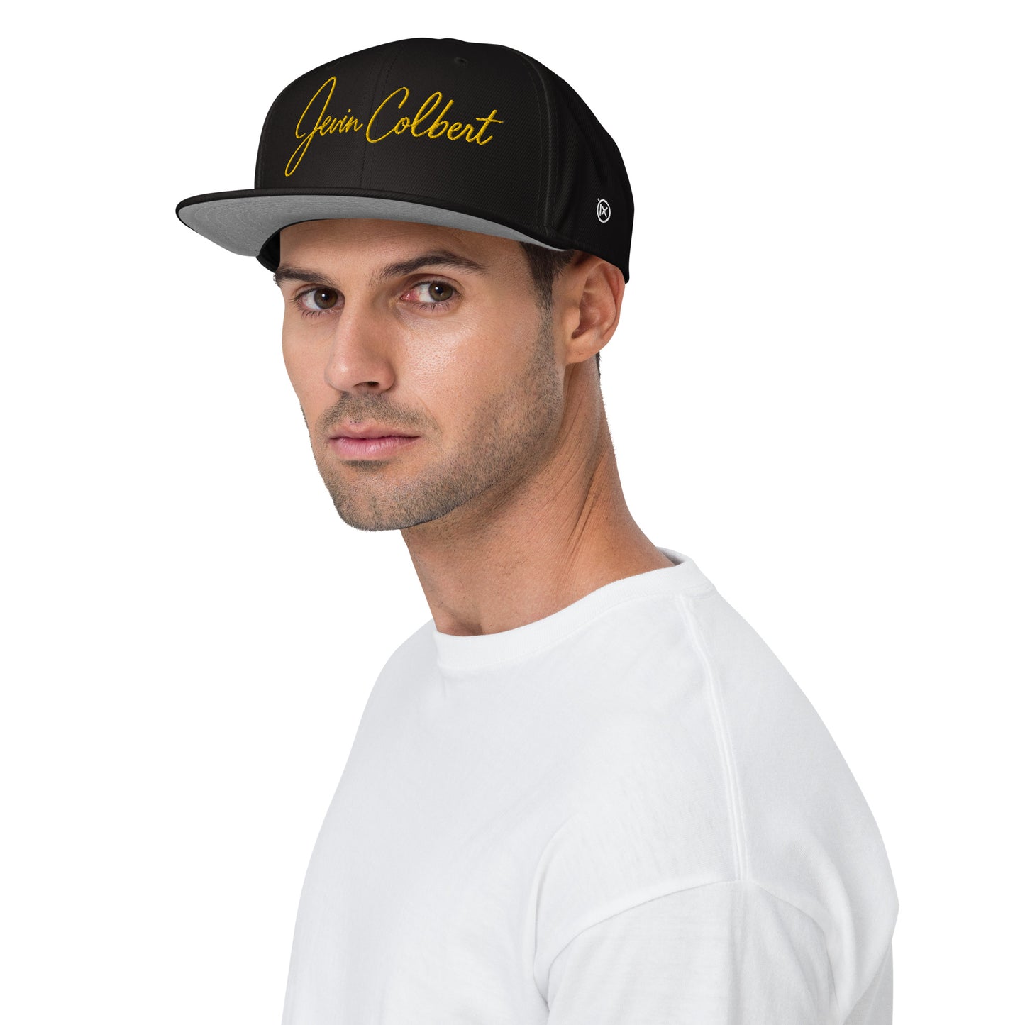 Black snapback cap with Jevin Colbert logo on the front panel and curved brim