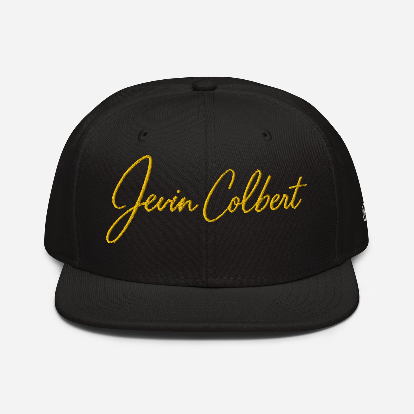 Black snapback cap with yellow “Jevin Colbert” script embroidery on the front panel