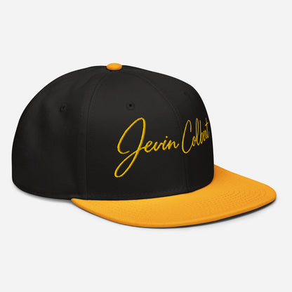 Black snapback cap with orange underside brim and yellow Jevin Colbert script logo