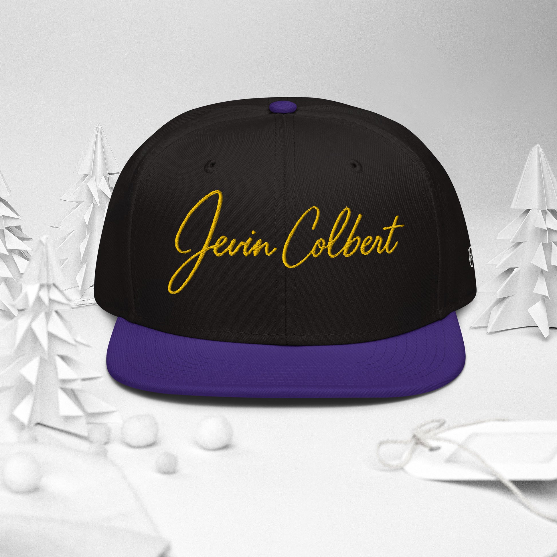 Black snapback cap with Jevin Colbert logo and purple flat brim