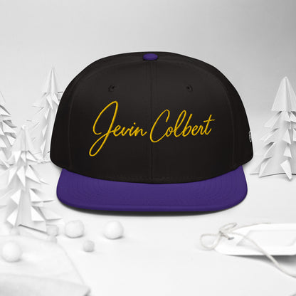 Black snapback cap with Jevin Colbert logo and purple flat brim