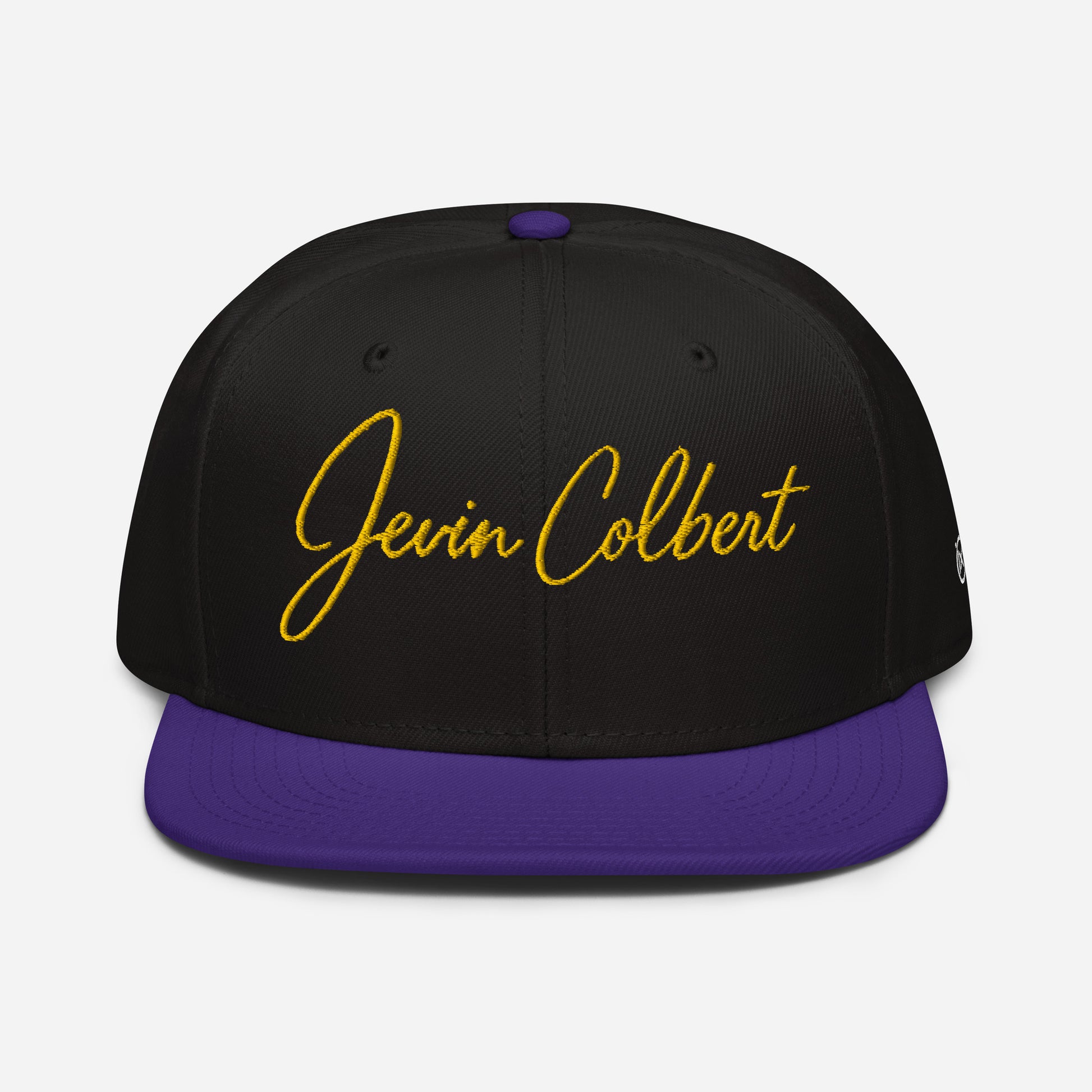 Black snapback cap with purple underside brim and yellow Jevin Colbert logo front