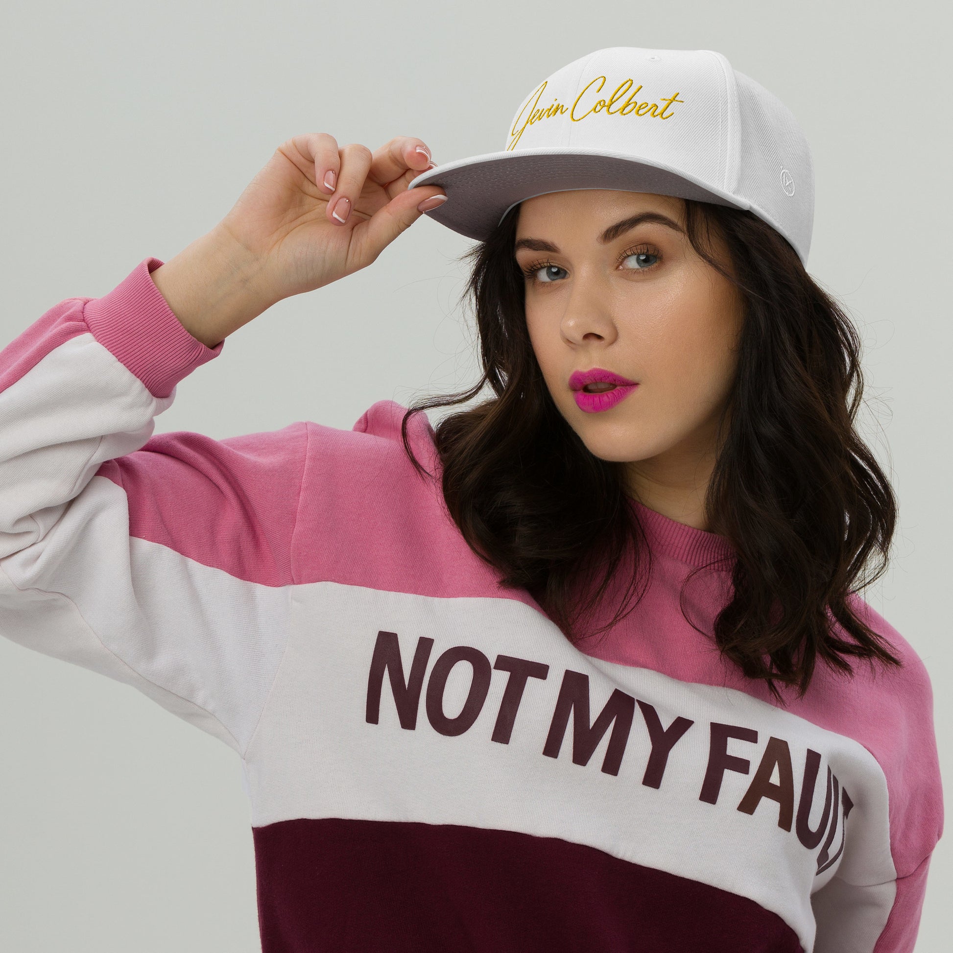 Jevin Colbert snapback cap on model, white front with yellow script logo