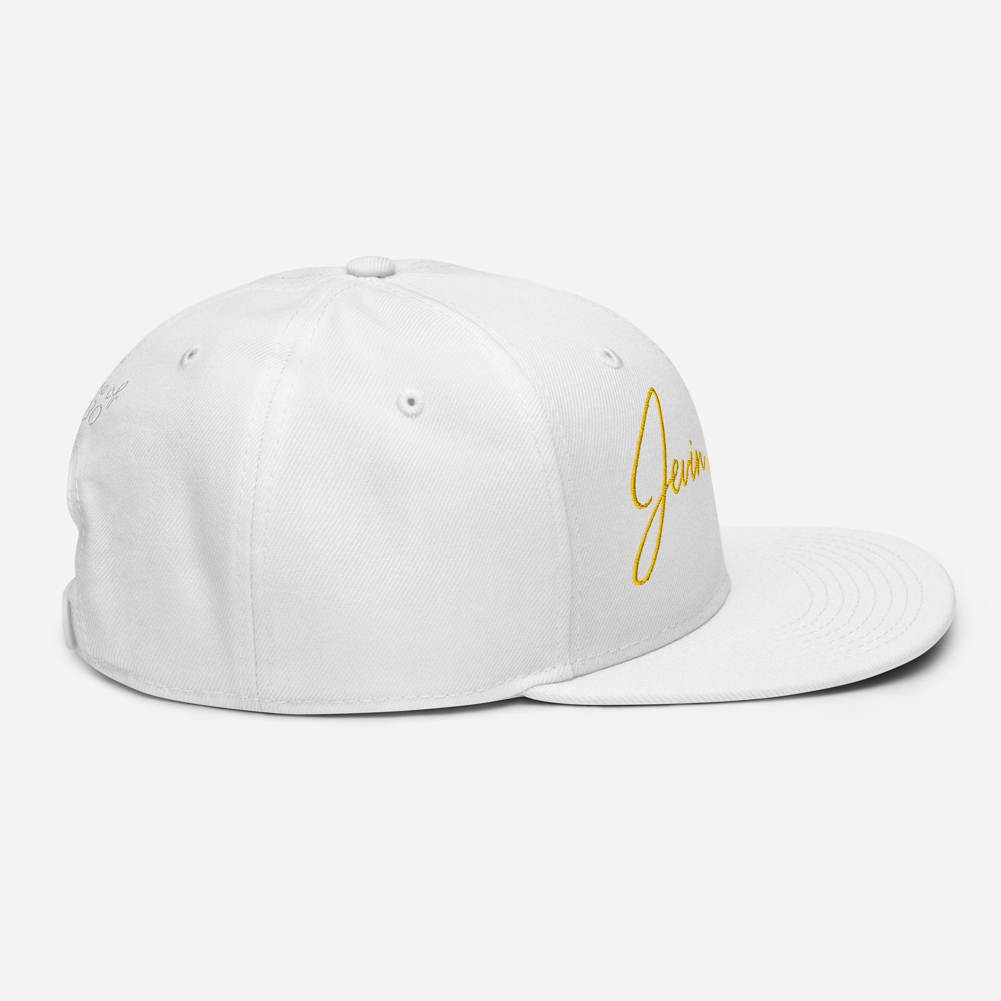 White snapback cap with yellow Jevin Colbert script logo on side and back panels